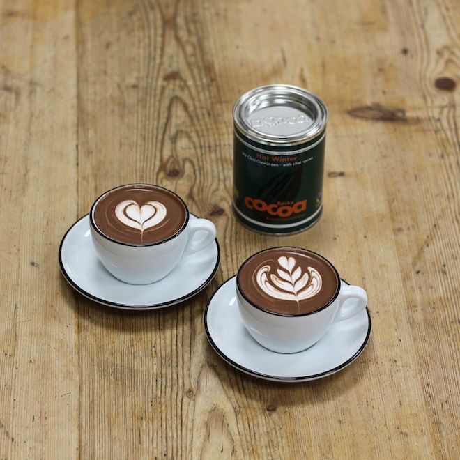 Zwei Tassen, gefüllt mit Hot Winter Trinkschokolade und Latte Art verziert