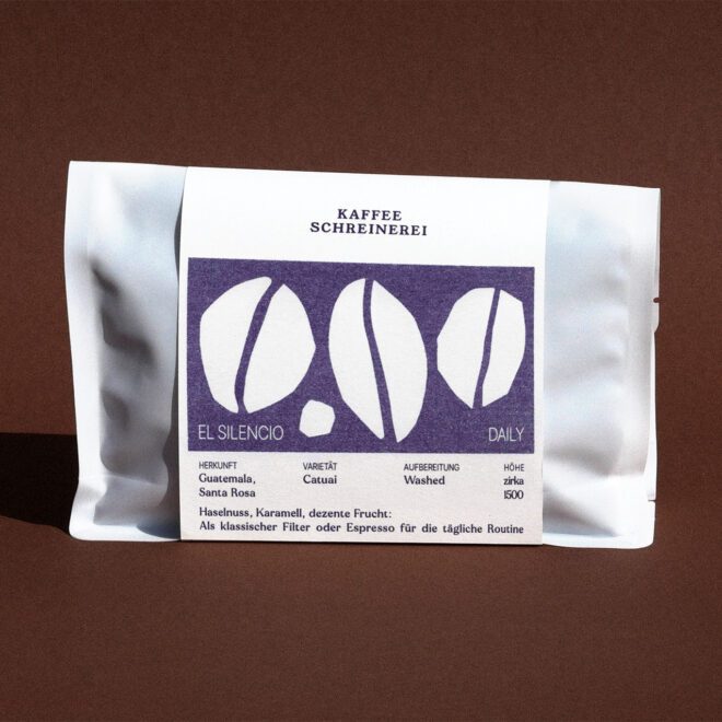 weisse Kaffeeverpackung mit lila Label auf braunem Hintergrund