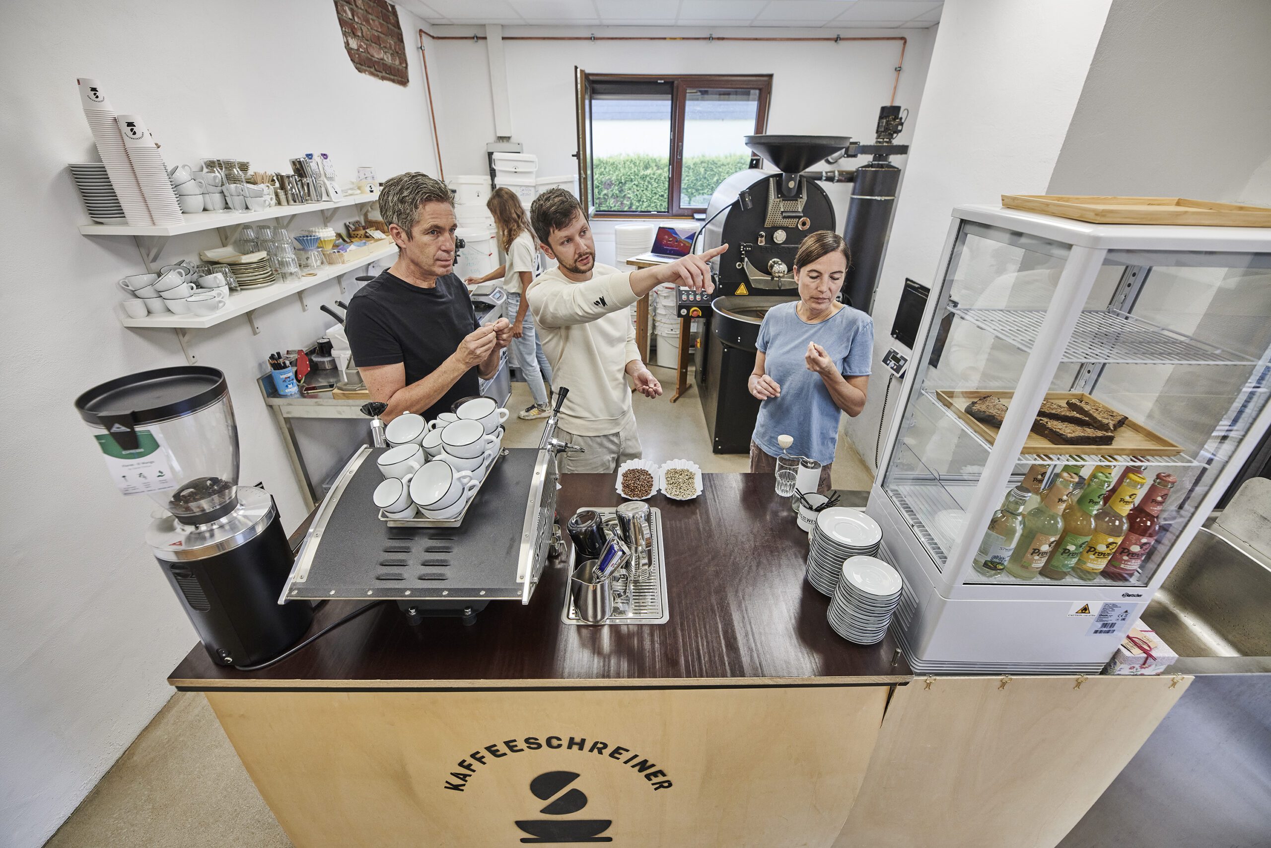 Kaffeeschreiner zeigt Kursteilnehmern auf Kaffeeschreiner Kaffeebar die Unterschiede bei Kaffeequalität
