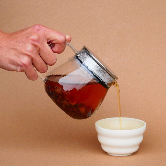 Aufgebrühter Cascara Tee in Kinto Kännchen, wird ausgeschenkt in Porzellan Tasse