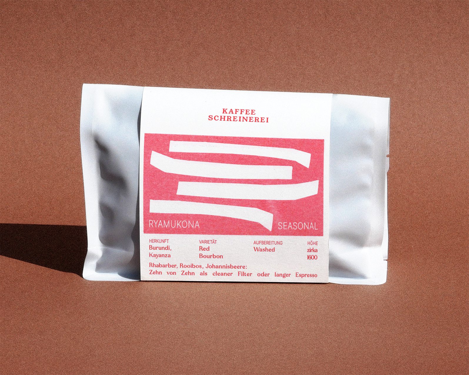 weisse Kaffeeverpackung mit rotem Label auf braunem Hintergrund