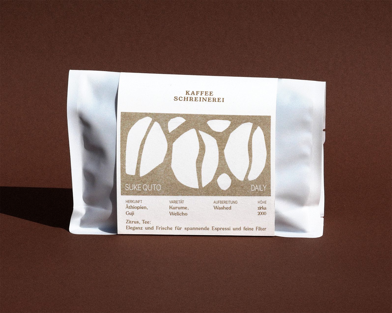 weisse Kaffeeverpackung mit flatgold Label auf braunem Hintergrund